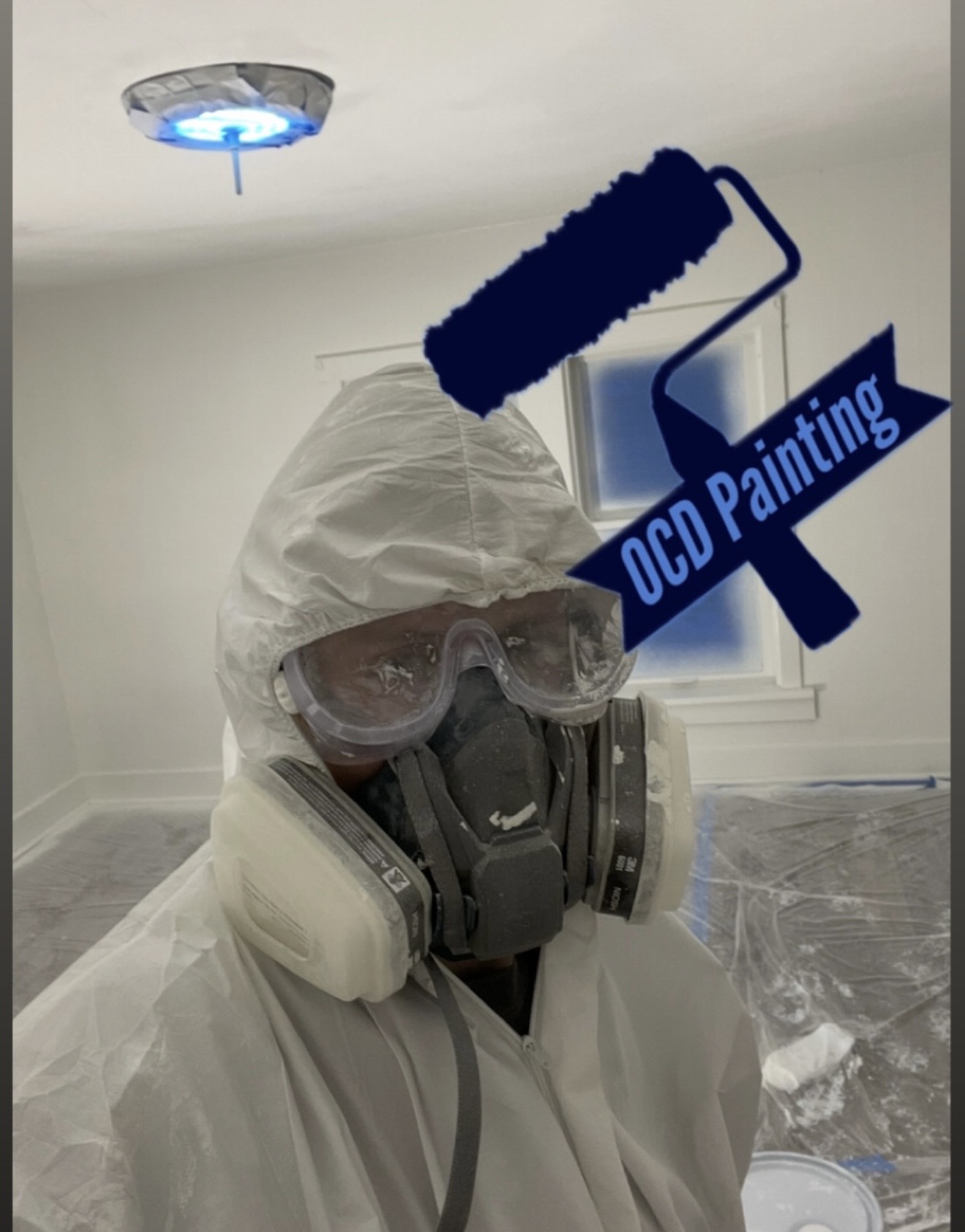 Logen in a protective suit, goggles, and respirator on an OCD Painting job