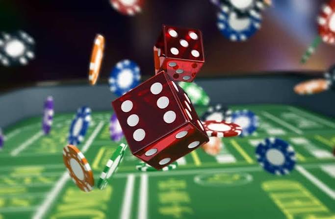 Red dice and chips in mid-roll over a table