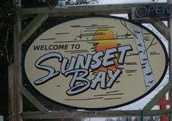 The "Welcome to Sunset Bay" sign
